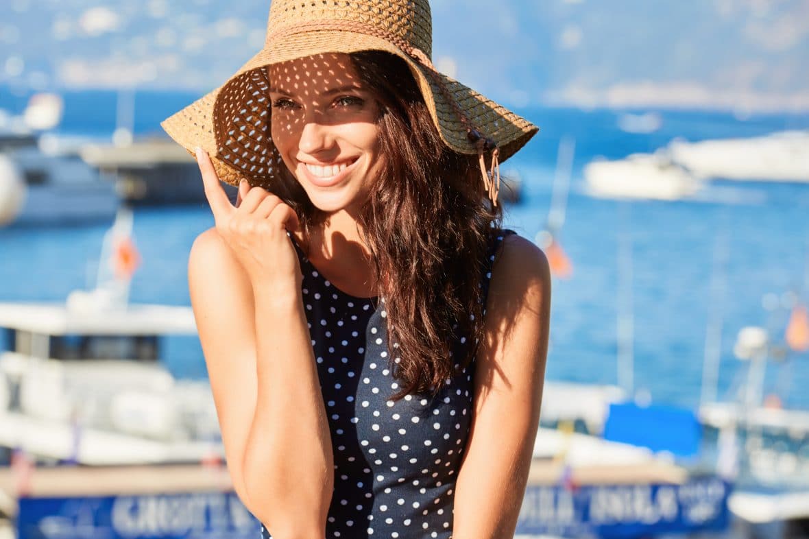 lovely girl in a hat protects her face from the sun