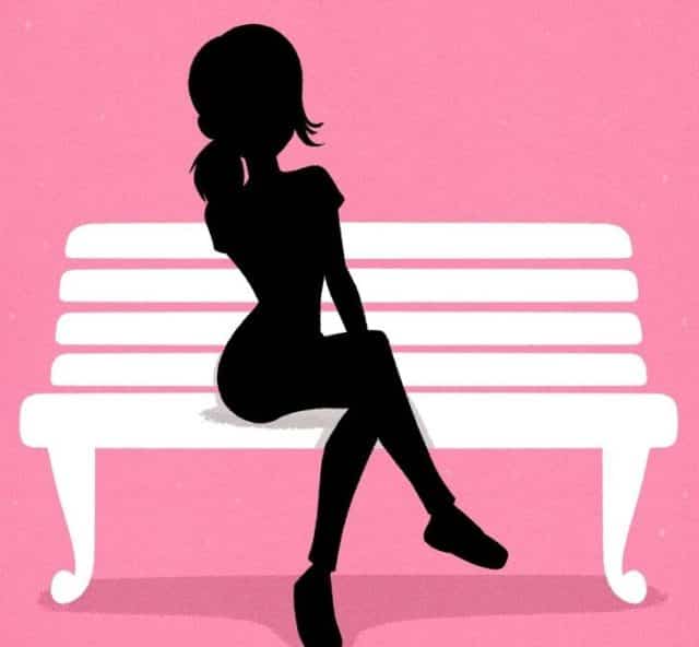 Девушка сидит на скамейке нога на ногу