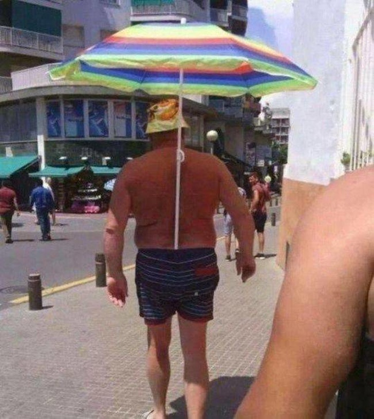 Мужчина с зонтиком в шортах