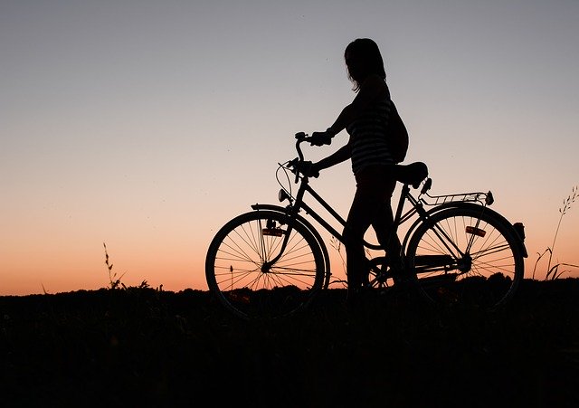 силуэт девушки с велосипедом на закате