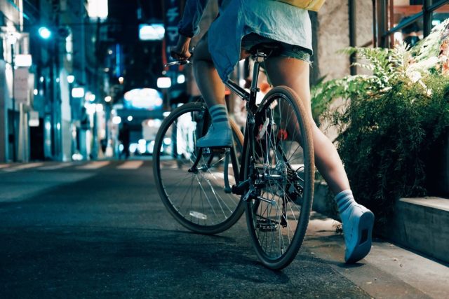 девушка едет на велосипеде по ночной улице