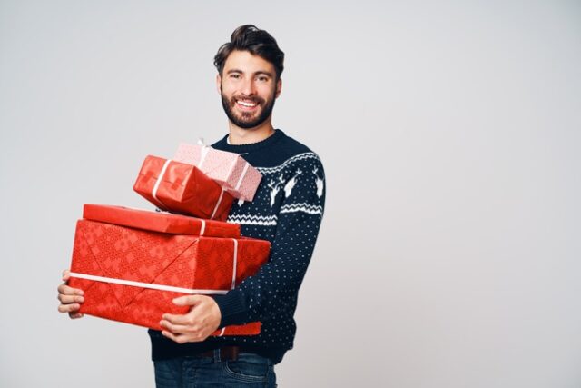 мужчина держит в руках коробки с подарками