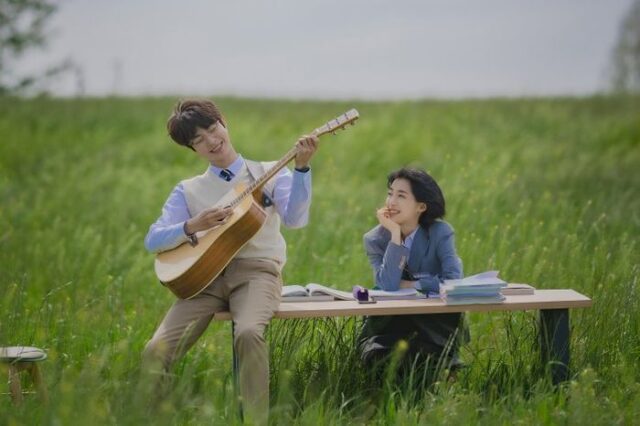 парень с гитарой и девушка за столом в поле