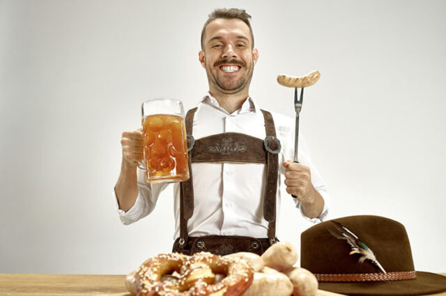 мужчина с бокалом пива и колбасой